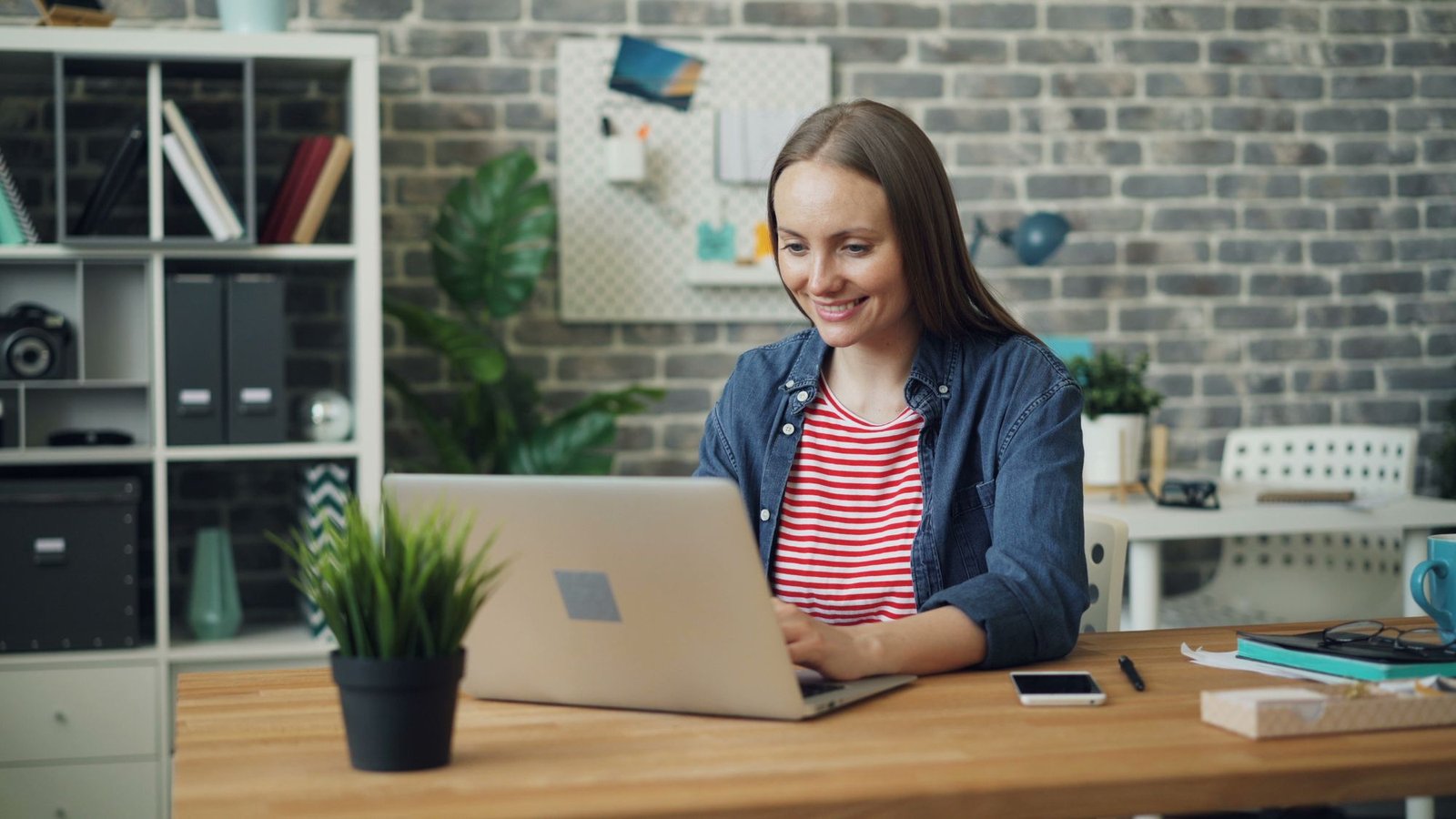 Smiling professional typing a personal message on a laptop